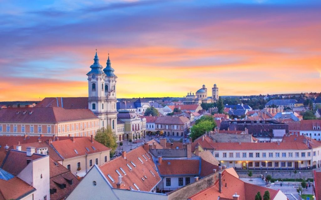 Panorama Egeru o zachodzie słońca z barokowym kościołem minoritów i czerwonymi dachami kamienic 