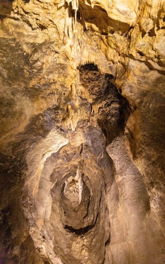 Stalaktyty zwisające ze stropu Jaskini Pál-völgyi nad spiralnym zagłębieniem skalnym