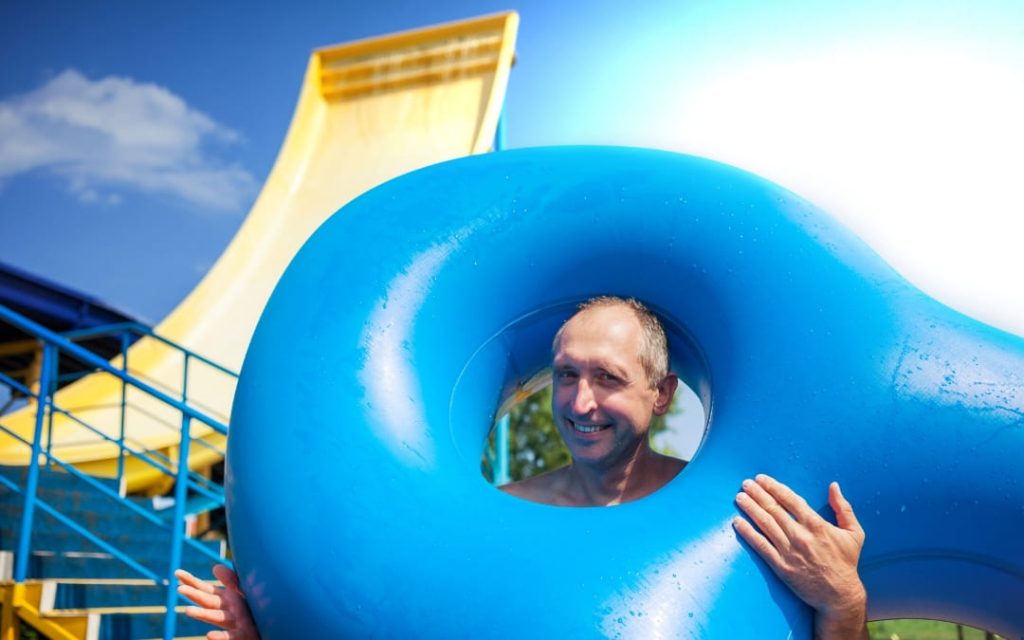 Uśmiechnięty mężczyzna w niebieskim kole w aquaparku