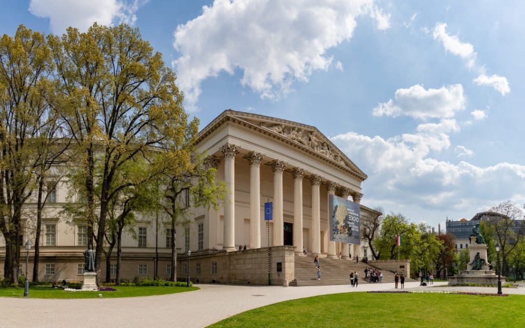 Węgierskie Muzeum Narodowe w Budapeszcie widziane z parku z neoklasyczną kolumnadą i rzeźbami