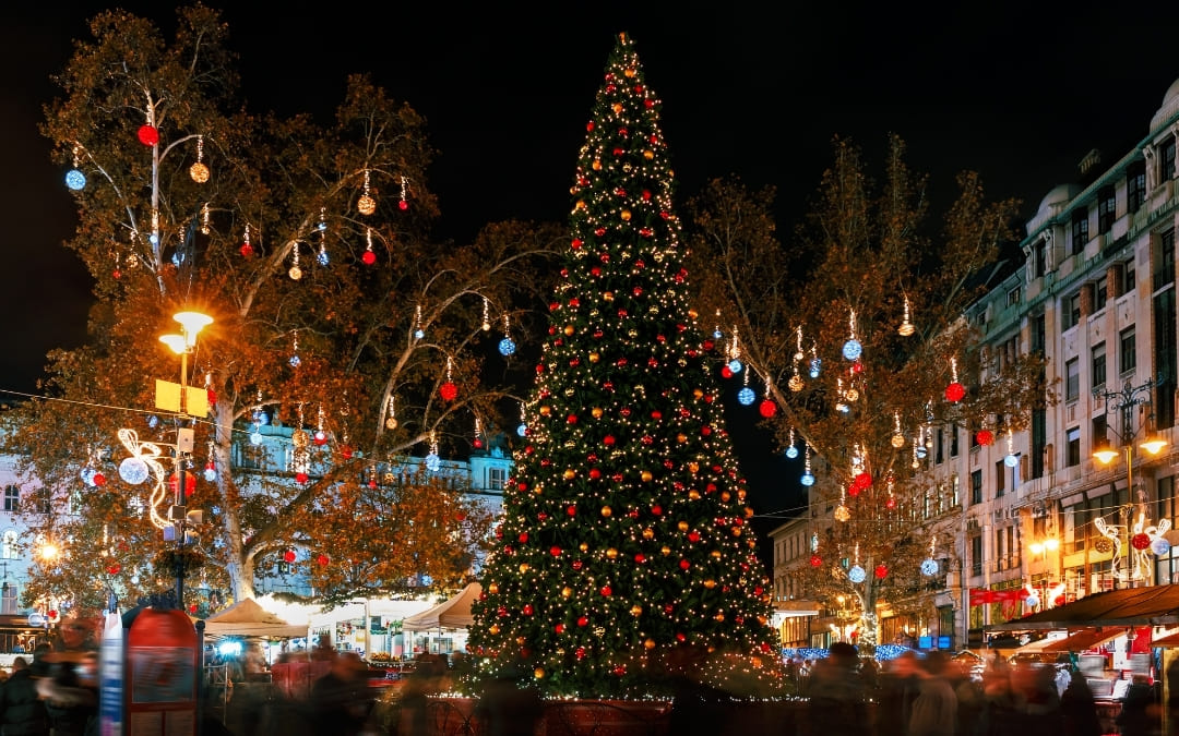 Wysoka ozdobiona choinka na jarmarku bożonarodzeniowym w Budapeszcie nocą