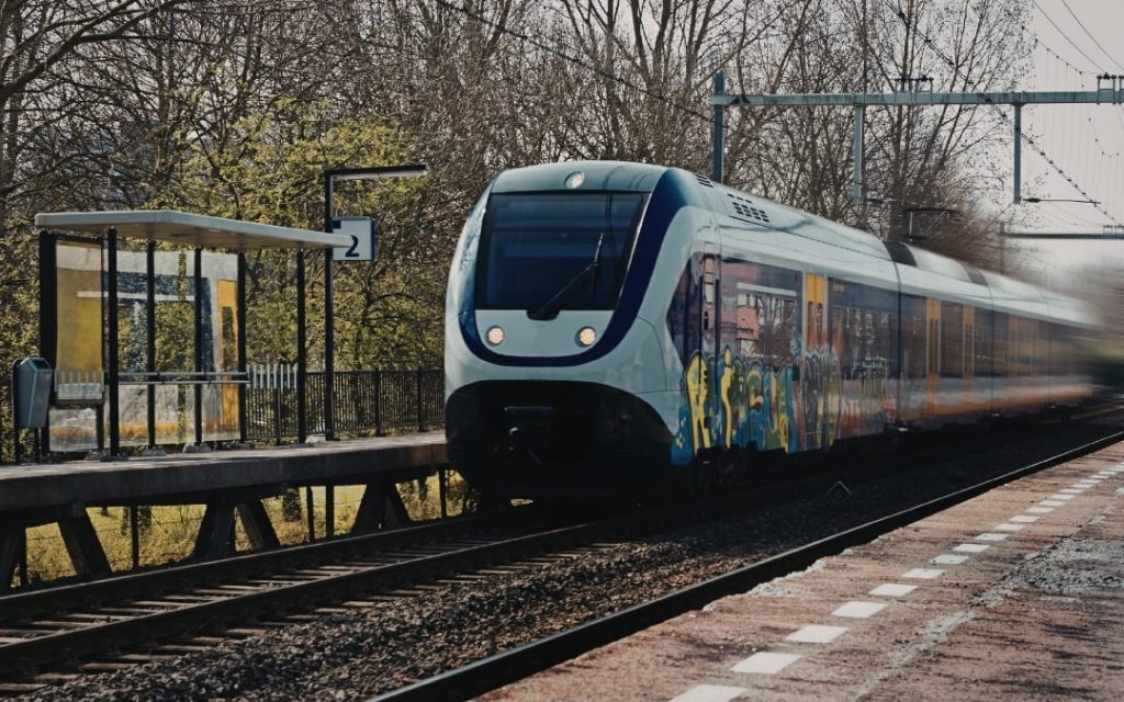 Nowoczesny pociąg pasażerski stojący na stacji kolejowej wśród zieleni