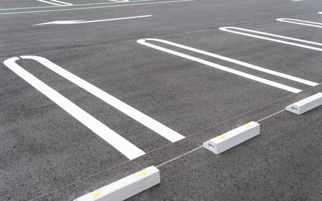 Puste miejsca parkingowe z białymi liniami na szarym asfalcie