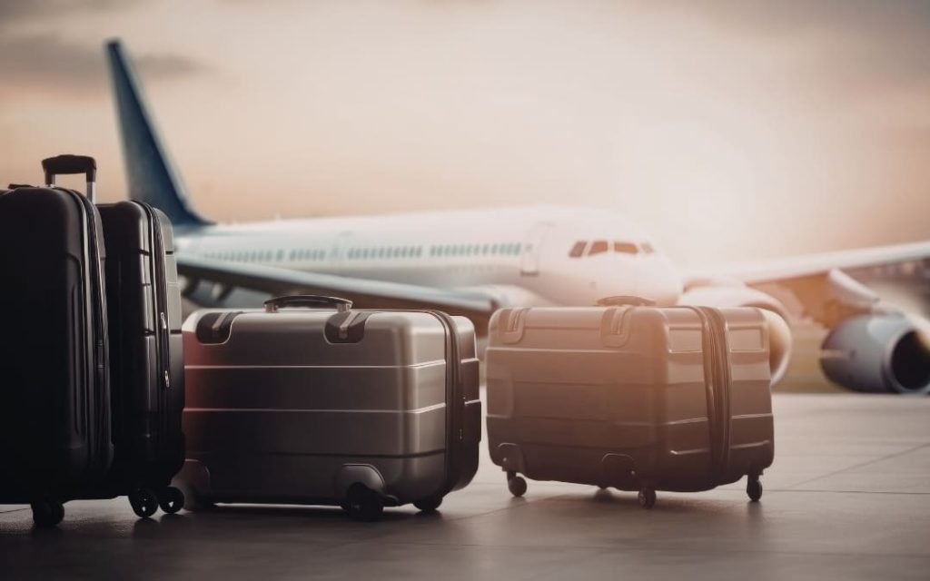 Ujęcie na walizki na lotnisku z samolotem w tle