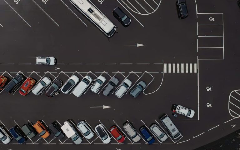 Widok z góry na zatłoczony parking z rzędami zaparkowanych samochodów