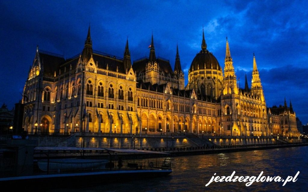 Parlament Węgier odbijający światła w wodach Dunaju nocą