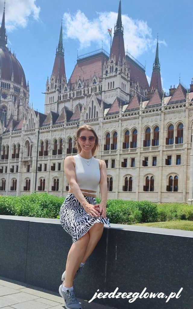 Turystka siedząca na murku przed Parlamentem w Budapeszcie