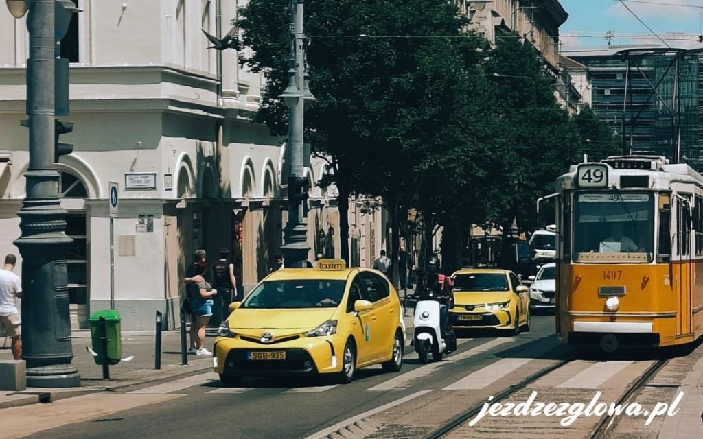 Żółty tramwaj i taksówka na ulicy w Budapeszcie
