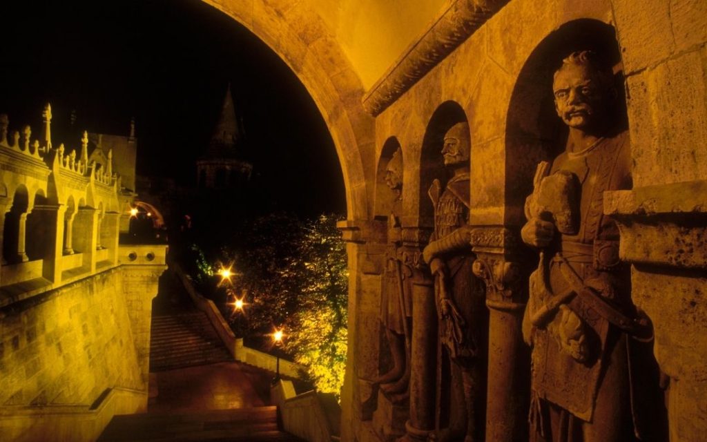 Rzeźby przy wejściu na Wzgórze Królewskie oświetlone nocą w Budapeszcie