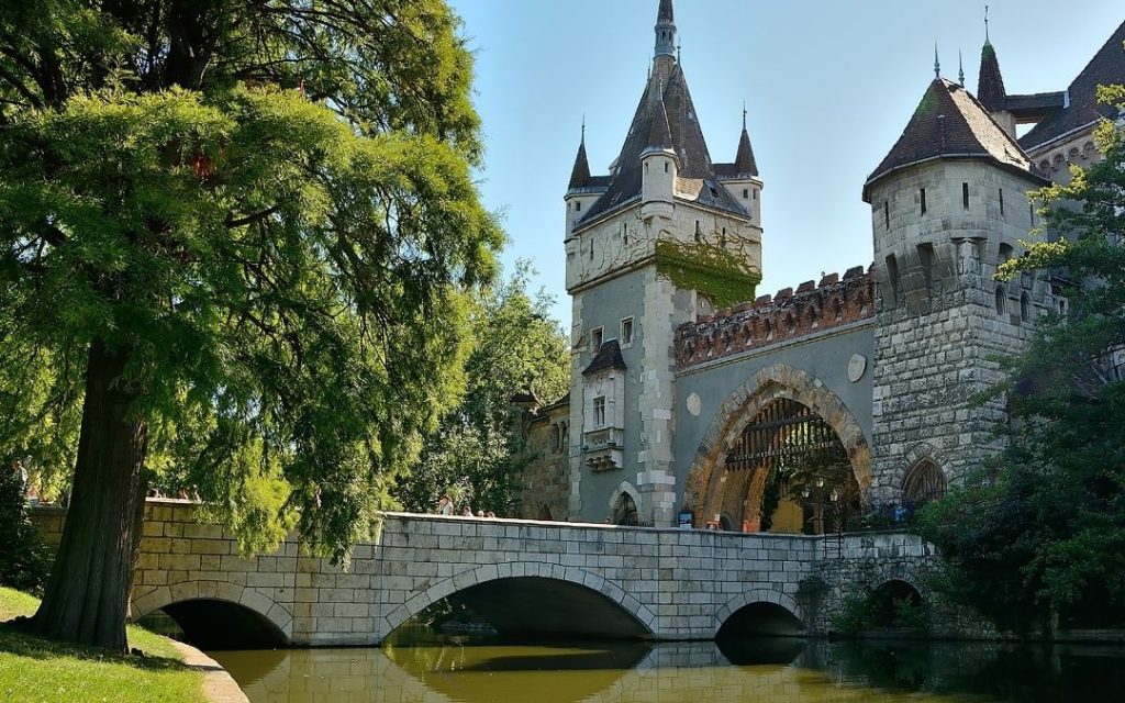 Zamek Vajdahunyad odbijający się w wodzie w słoneczny dzień w Budapeszcie