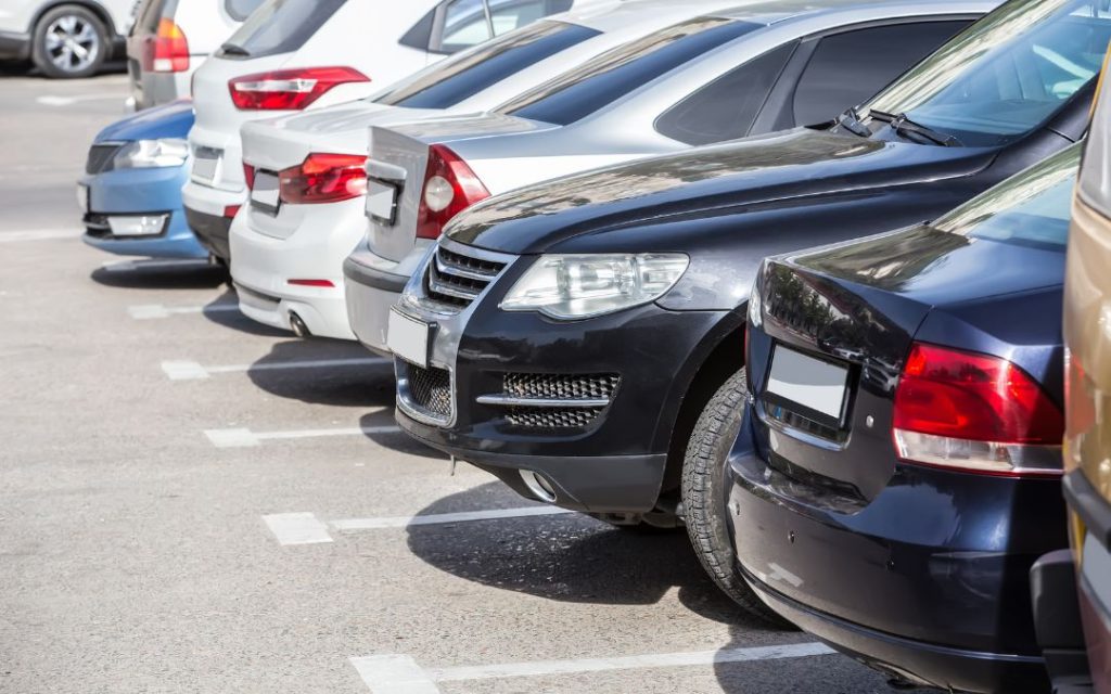 Szereg samochodów zaparkowanych obok siebie na parkingu