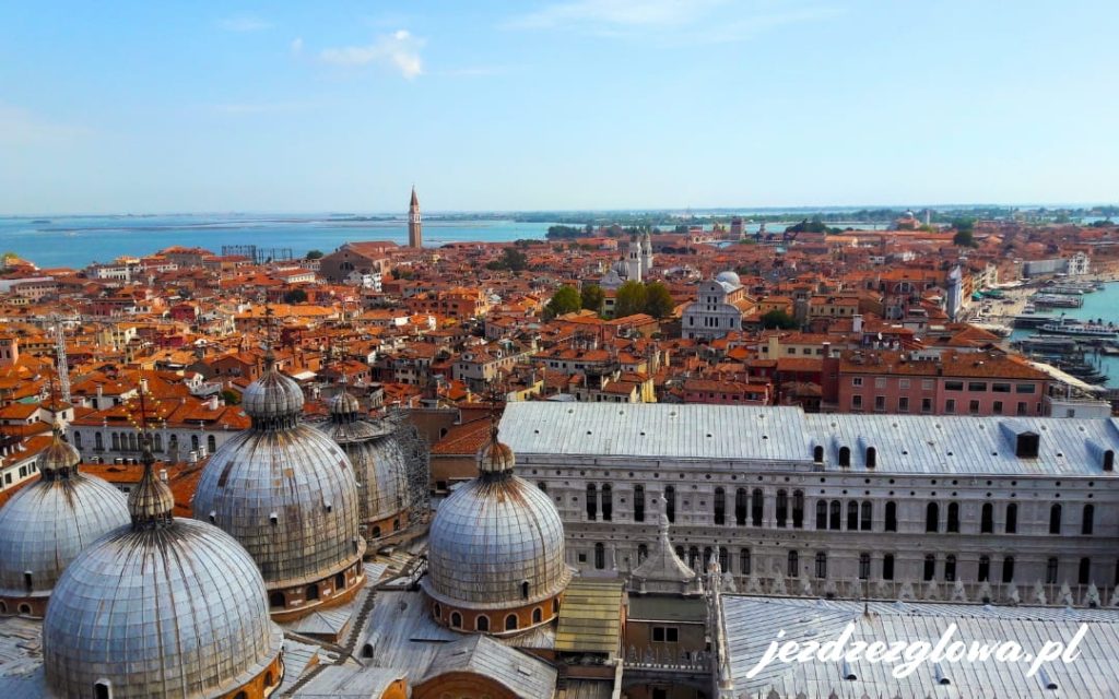 Widok z góry na dachy Wenecji i kopuły Bazyliki św. Marka z laguną w tle