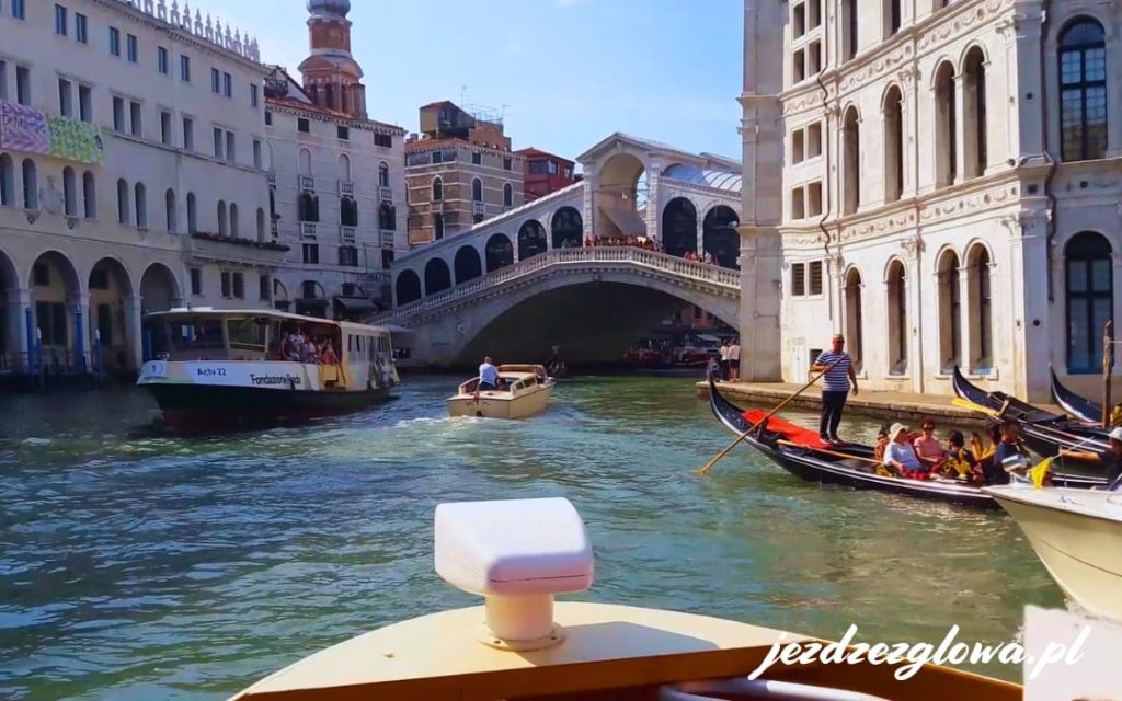 Widok z łodzi na Most Rialto w Wenecji z gondolami, vaporetto i motorówkami na Canal Grande