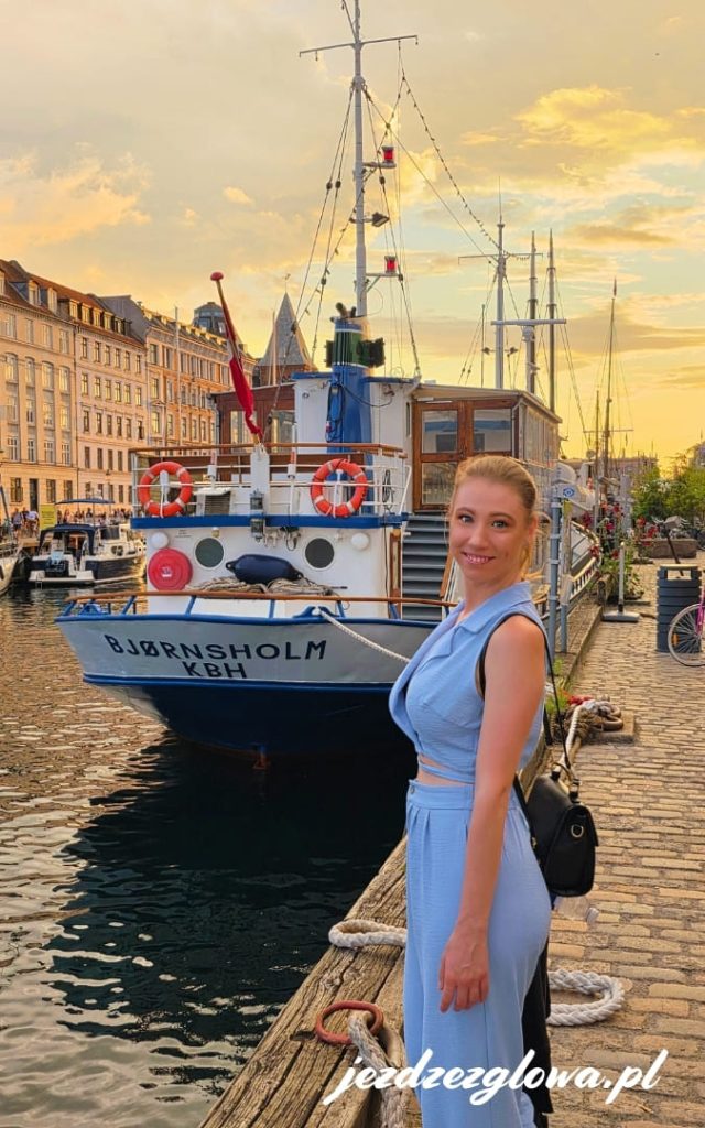 Zdjęcie przy kanale Nyhavn w Kopenhadze o zachodzie słońca z widokiem na żaglowiec