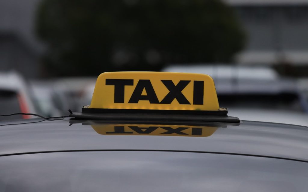 Żółty szyld taxi na dachu samochodu