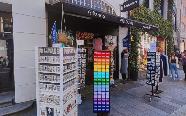 Stojaki z magnesami i pocztówkami przed sklepem w Kopenhadze