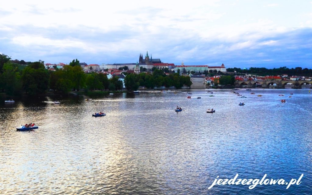 Łódki na wodzie a w tle panorama Pragi