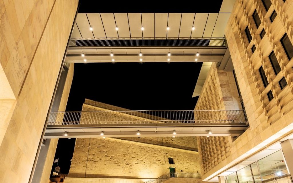 Nowoczesna architektura budynku Parlamentu w Valletcie na Malcie, widok nocą z oświetlonymi przejściami