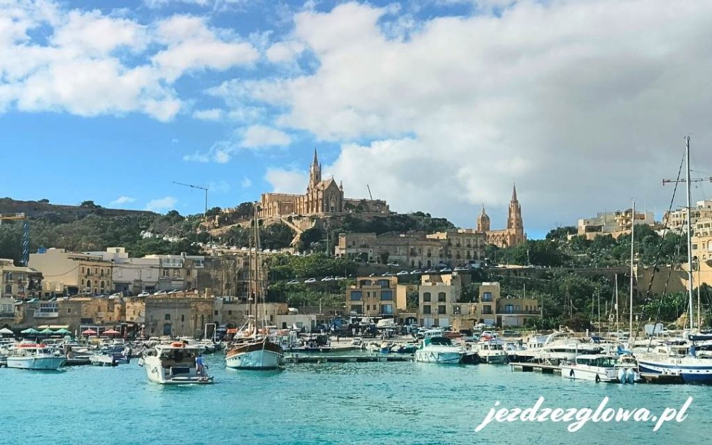 Port w miejscowości na Gozo, z widokiem na wzgórze z kościołem i otaczającymi budynkami