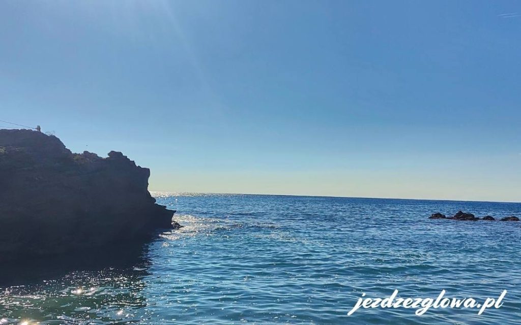 Delikatne fale uderzające o plażę, z widokiem na skały na brzegu