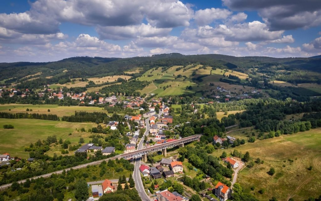 Miasteczko w sudeckiej dolinie z historycznym wiaduktem kolejowym widziane z lotu ptaka