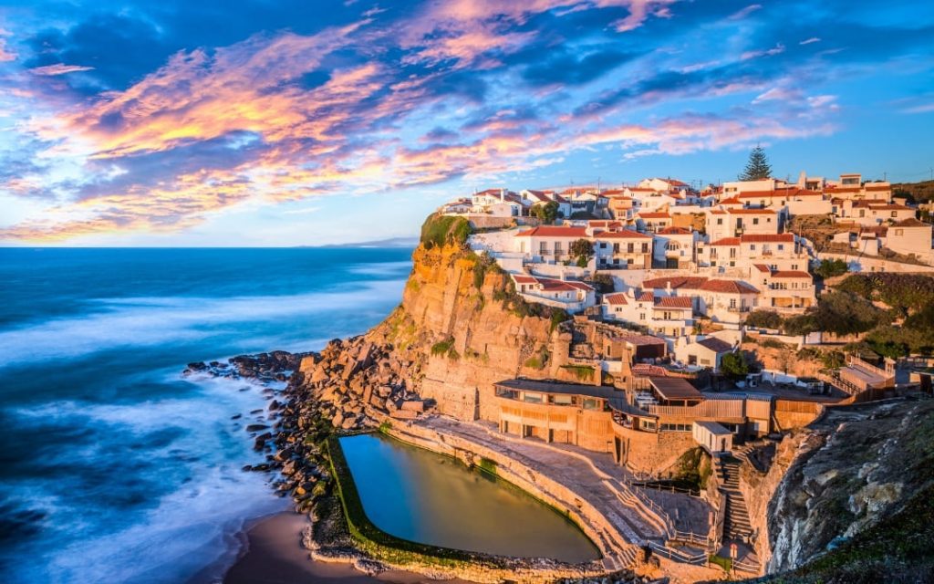 Nadmorska wioska Azenhas do Mar w Portugalii z białymi domami na skale i basenem u podnóża