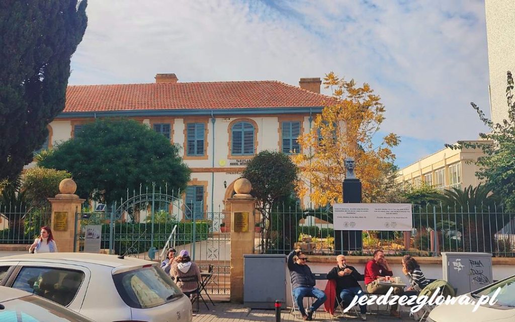 Obraz spokojnej alejki z samochodami i ludźmi odpoczywającymi