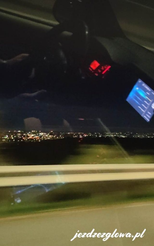 Oświetlone miasto nocą w czasie jazdy autem
