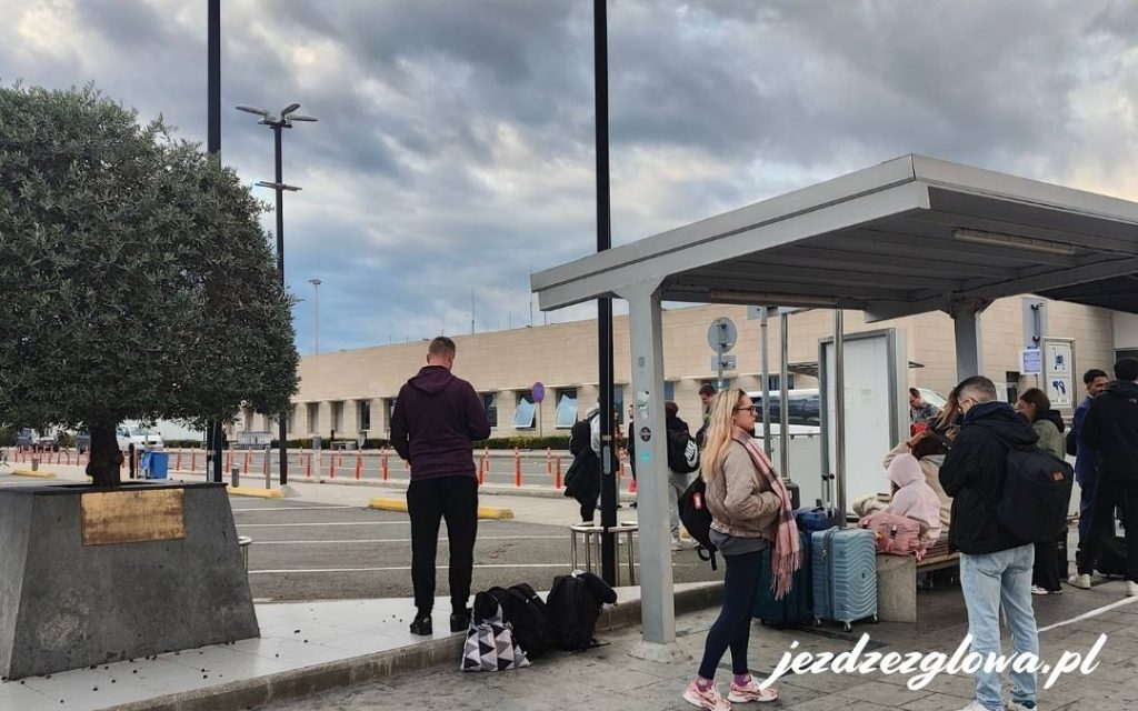 Pasażerowie odpoczywający przed terminalem w Pafos
