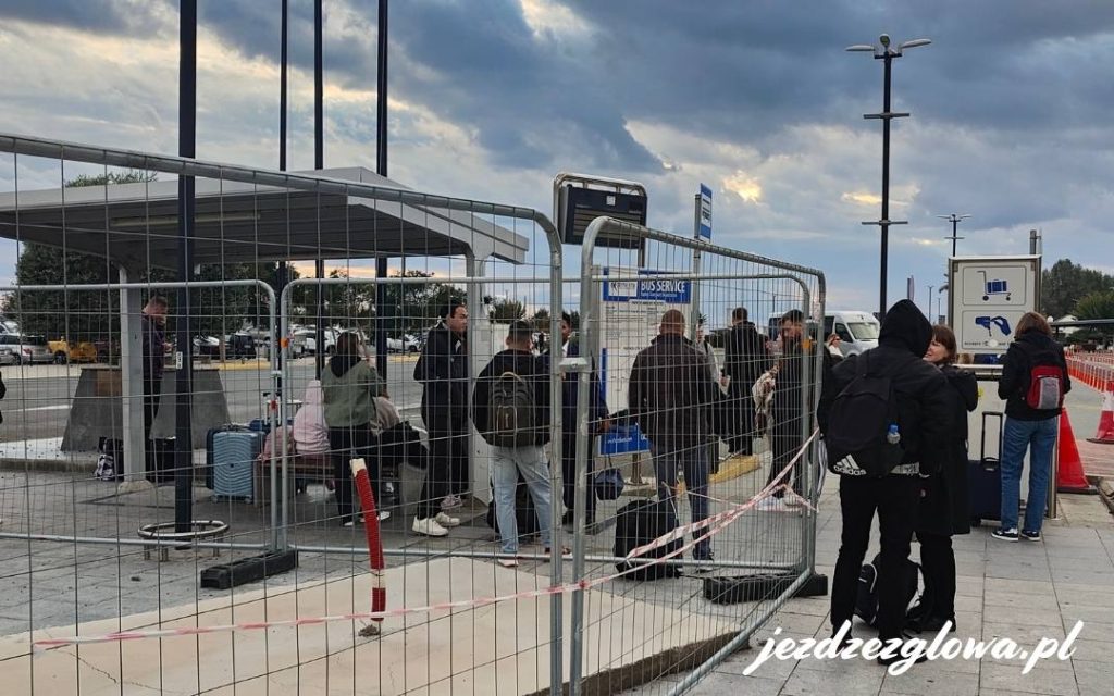 Podróżni przy przystanku autobusowym na lotnisku w Pafos