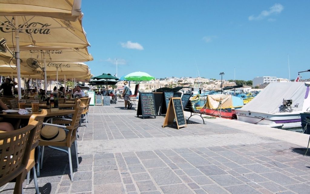 Promenada i restauracje nad morzem w Marsaxlokk, Malta