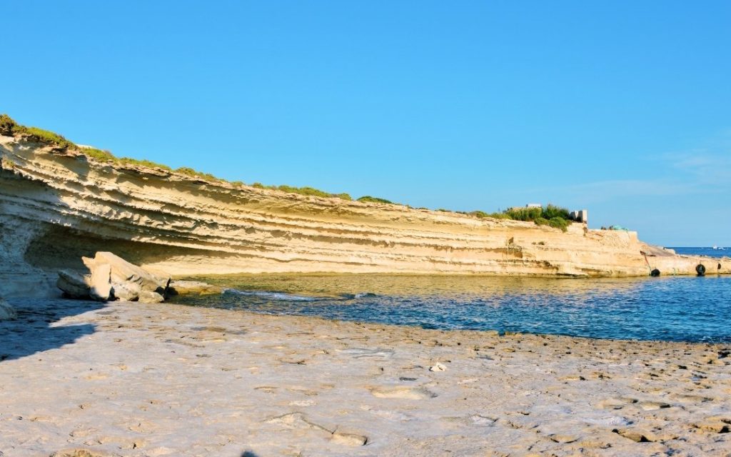 St. Peter's Pool na Malcie, z klifami i płaskimi formacjami skalnymi