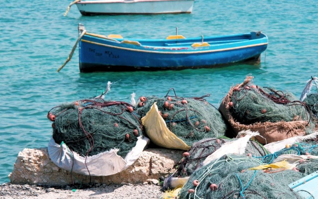 Tradycyjne sieci rybackie na brzegu w pobliżu maltańskiej łodzi luzzu
