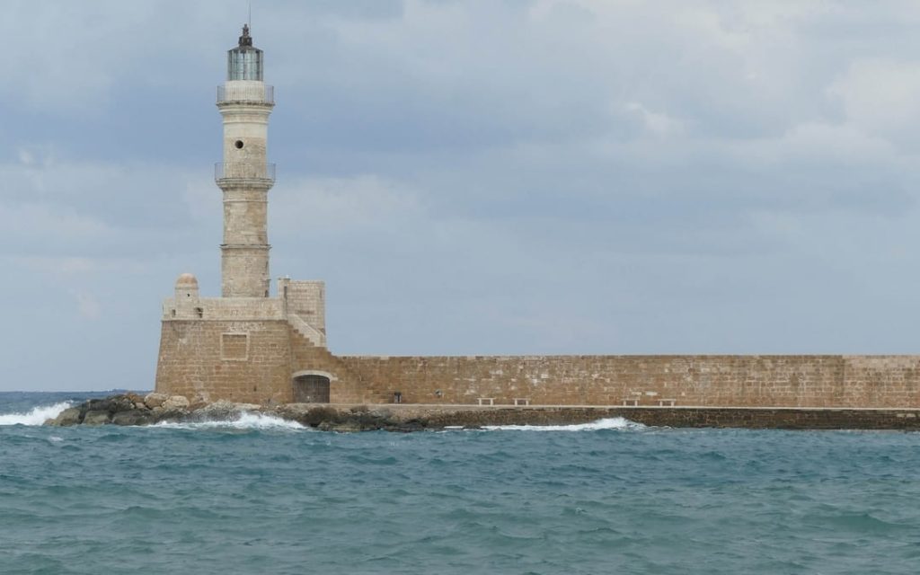 Wenecka latarnia morska w starym porcie w Chanii na Krecie na tle zachmurzonego nieba