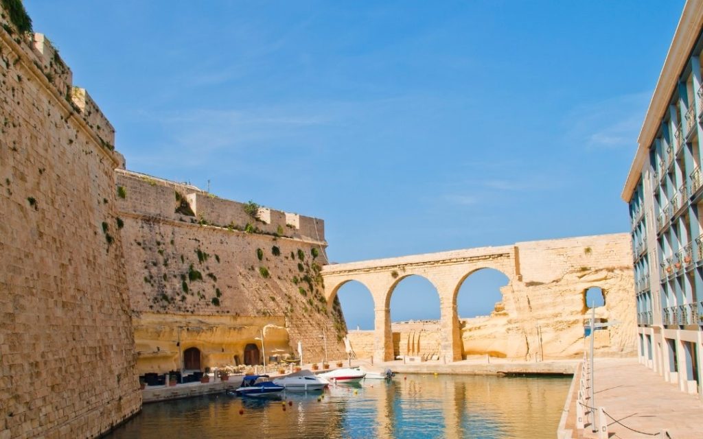 Widok na mury forteczne Birgu i most z łukami