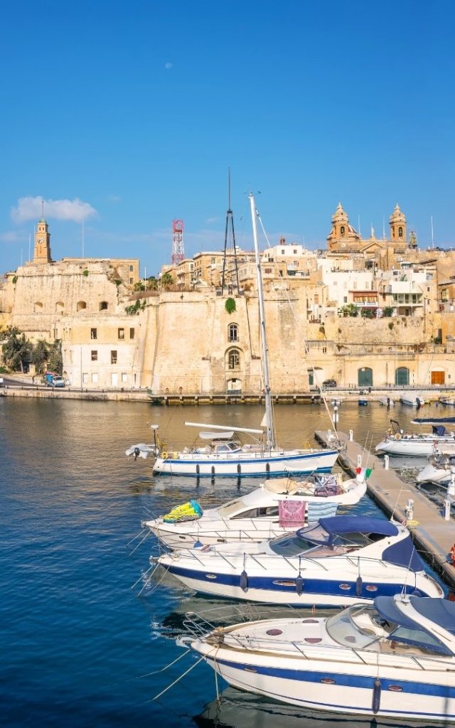 Widok na port w Senglei, z zacumowanymi łodziami i malowniczymi budynkami w tle