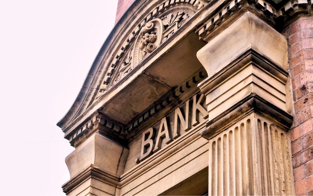 Zbliżenie na napis BANK na fasadzie zabytkowego budynku
