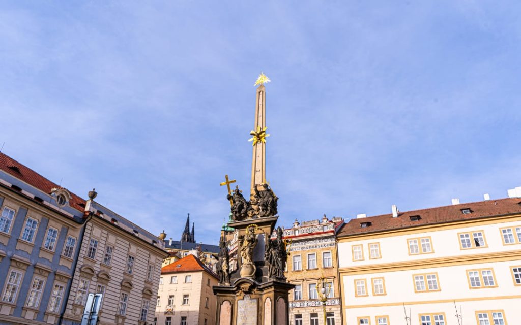 Barokowa kolumna morowa na Małostranskim Rynku w Pradze na tle błękitnego nieba