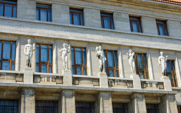 Fasada Miejskiej Biblioteki w Pradze z rzędem białych rzeźb figuralnych na gzymsie budynku
