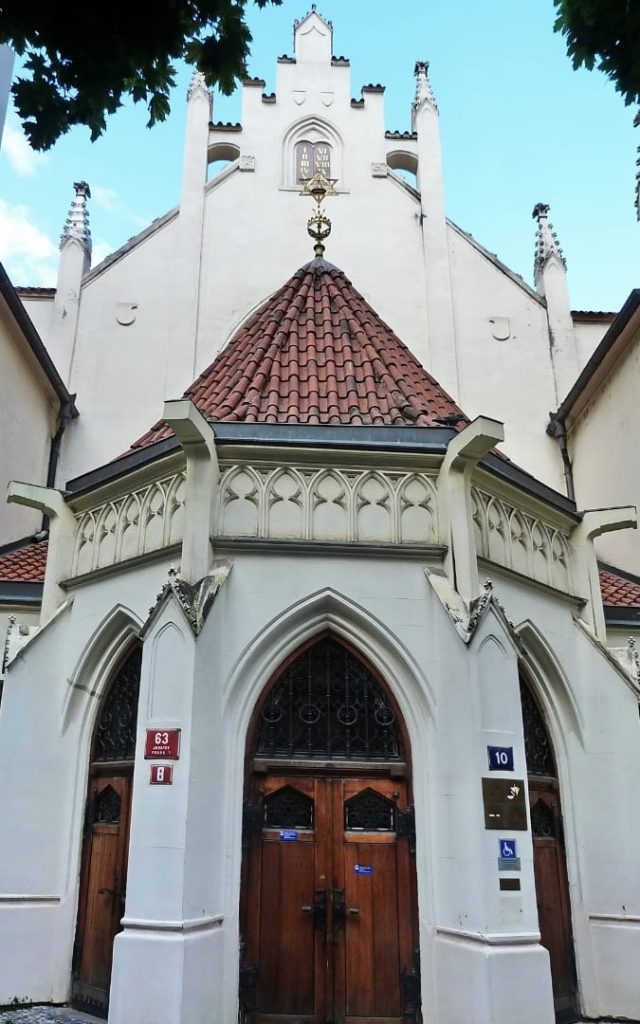 Gotycka fasada Synagogi Majsela w Pradze z drewnianymi drzwiami i czerwonym dachem
