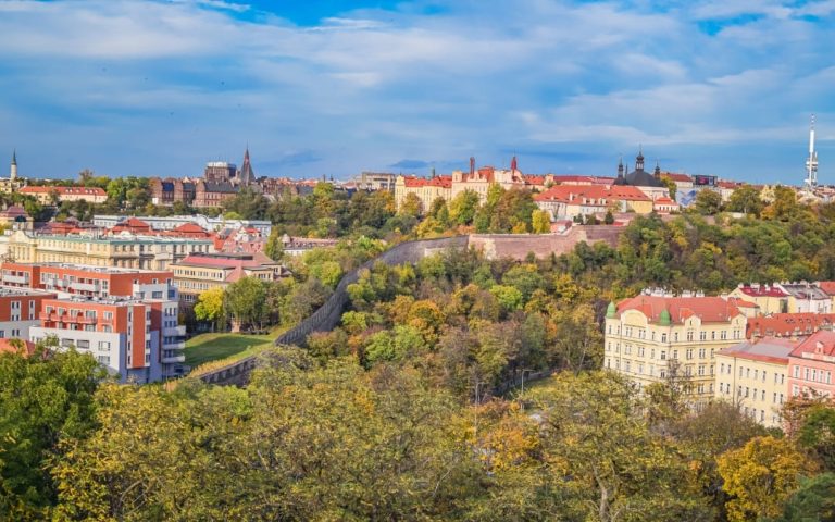 Jesienna panorama Pragi z wzgórza Wyszehrad z murami obronnymi i Wieżą Telewizyjną Žižkov w tle