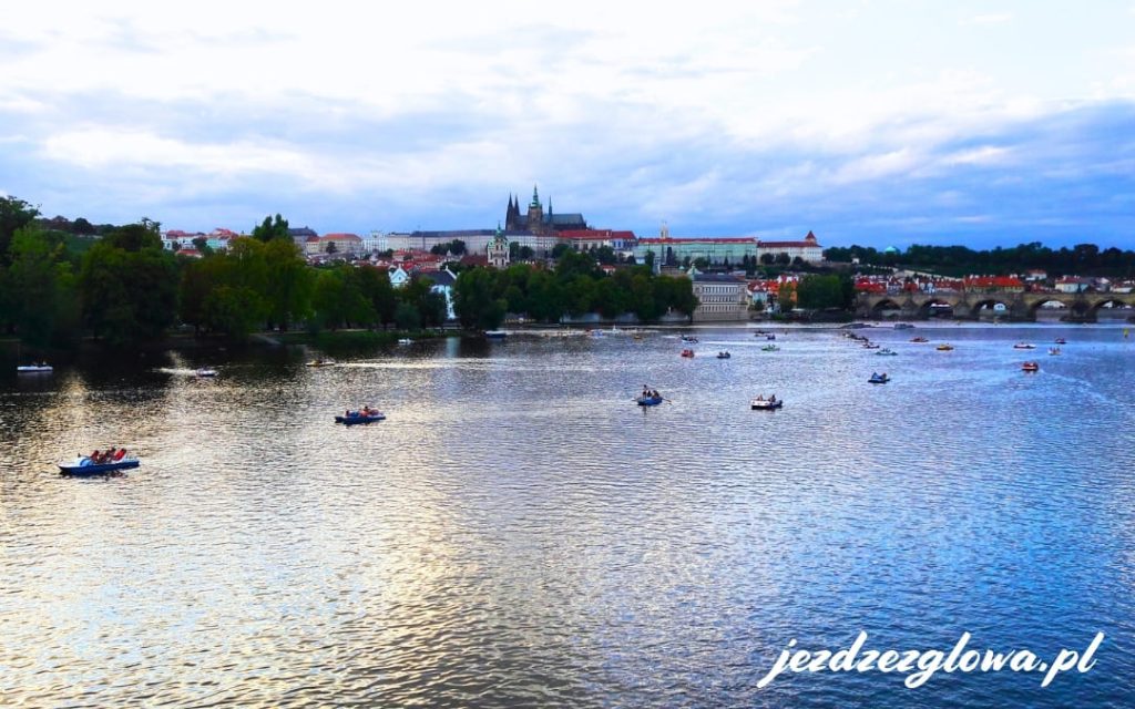 Łódki na wodzie a w tle panorama Pragi