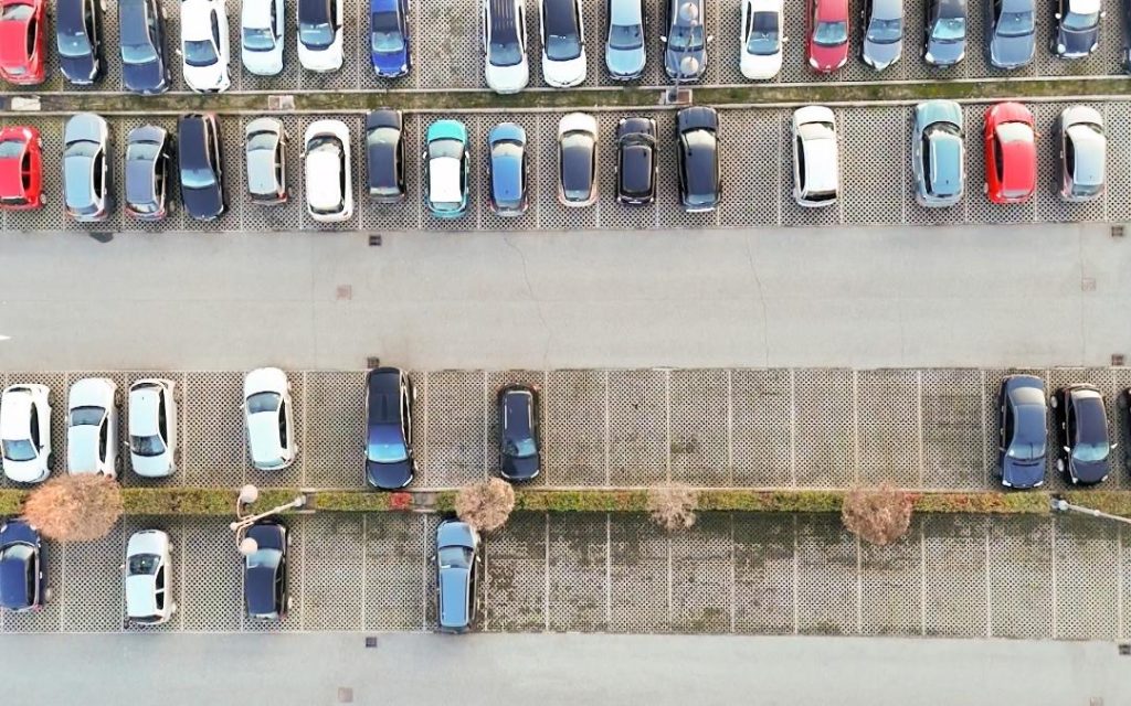 Parking samochodowy widziany z góry, z rzędami zaparkowanych aut