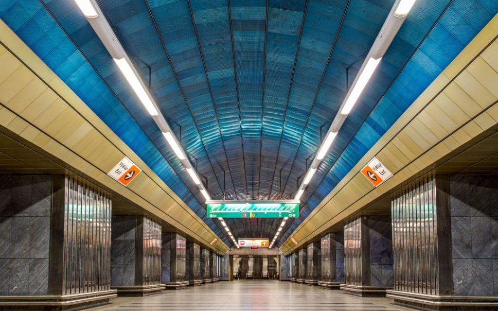 Peron praskiego metra z efektownym niebieskim sklepieniem i szarymi marmurowymi kolumnami