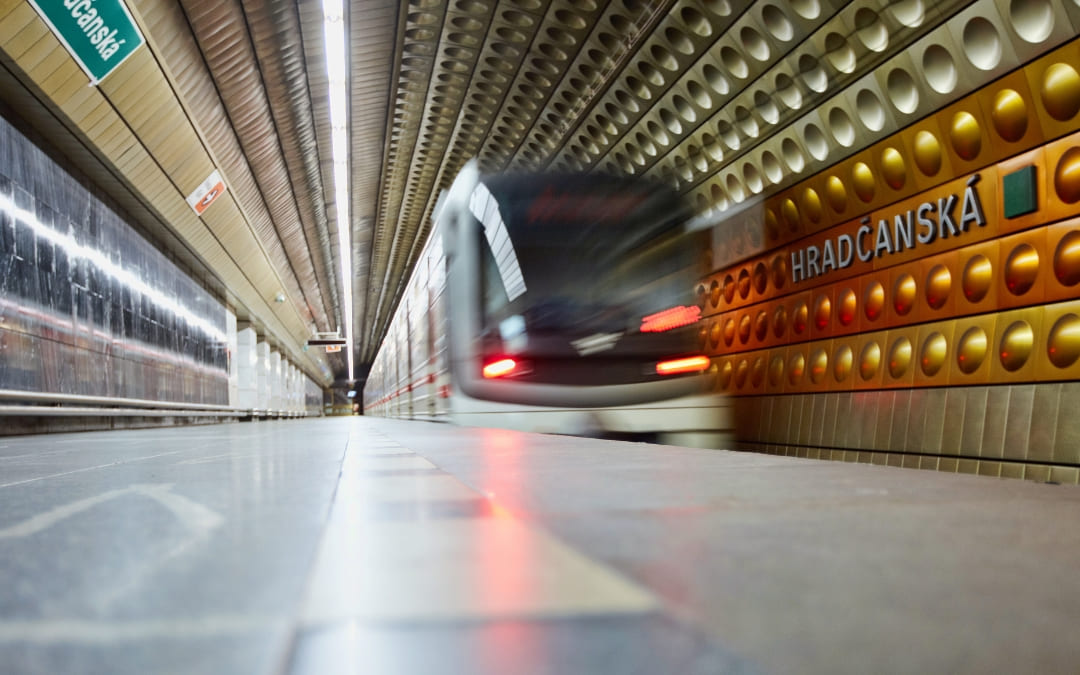 Pociąg metra wjeżdżający na stację Hradčanská w Pradze z charakterystyczną złoto-brązową ścianą
