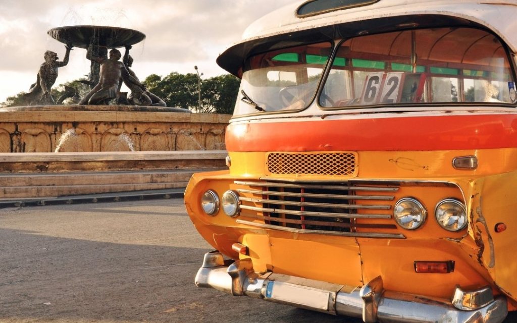 Zabytkowy maltański autobus zaparkowany przy fontannie w centrum miasta