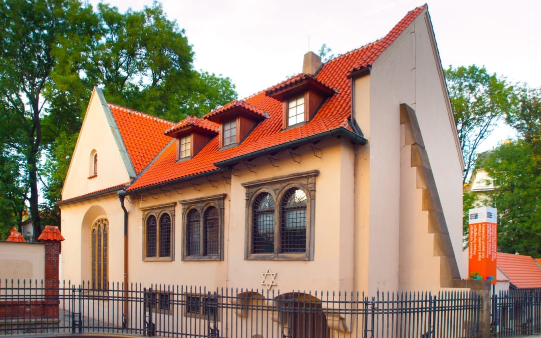Zewnętrzna fasada Synagogi Pinkasa w Pradze z czerwonym dachem i Gwiazdą Dawida