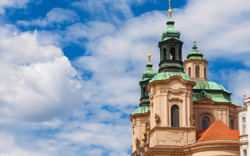Zielone barokowe kopuły Kościoła św. Mikołaja w Pradze na tle błękitnego nieba