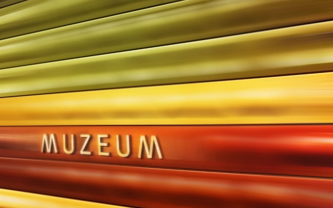 Złoto-czerwone ściany stacji metra Muzeum w Pradze z oświetlonym napisem Muzeum