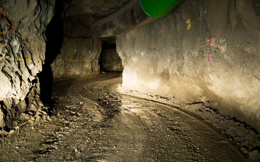 Wąski, surowy korytarz wykuty w skale – podziemna przestrzeń o militarnym charakterze